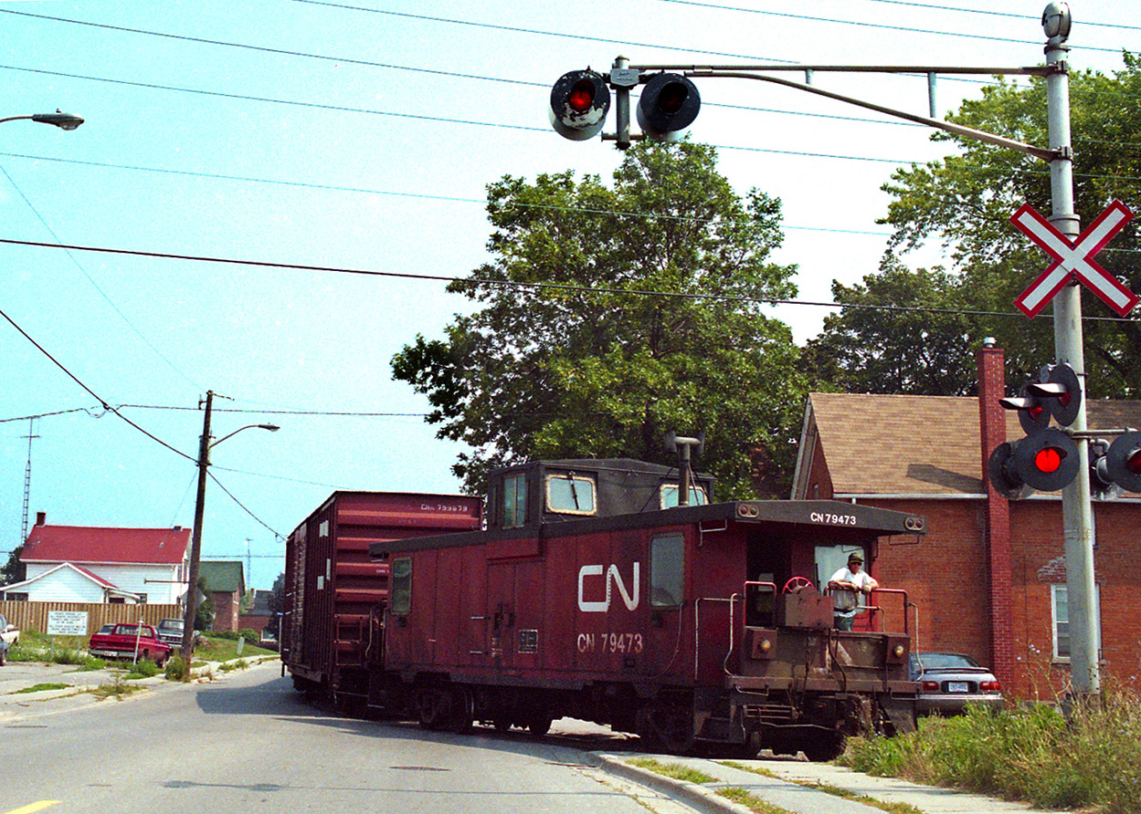 Just make a right when you get to Bruce Street... a member of the crew keeps  watch as a train hauling a string of 50 foot boxcars for the GM North Plant in Oshawa negotiates the 5 mph curve turning east onto Bruce Street not long before the plant was closed.