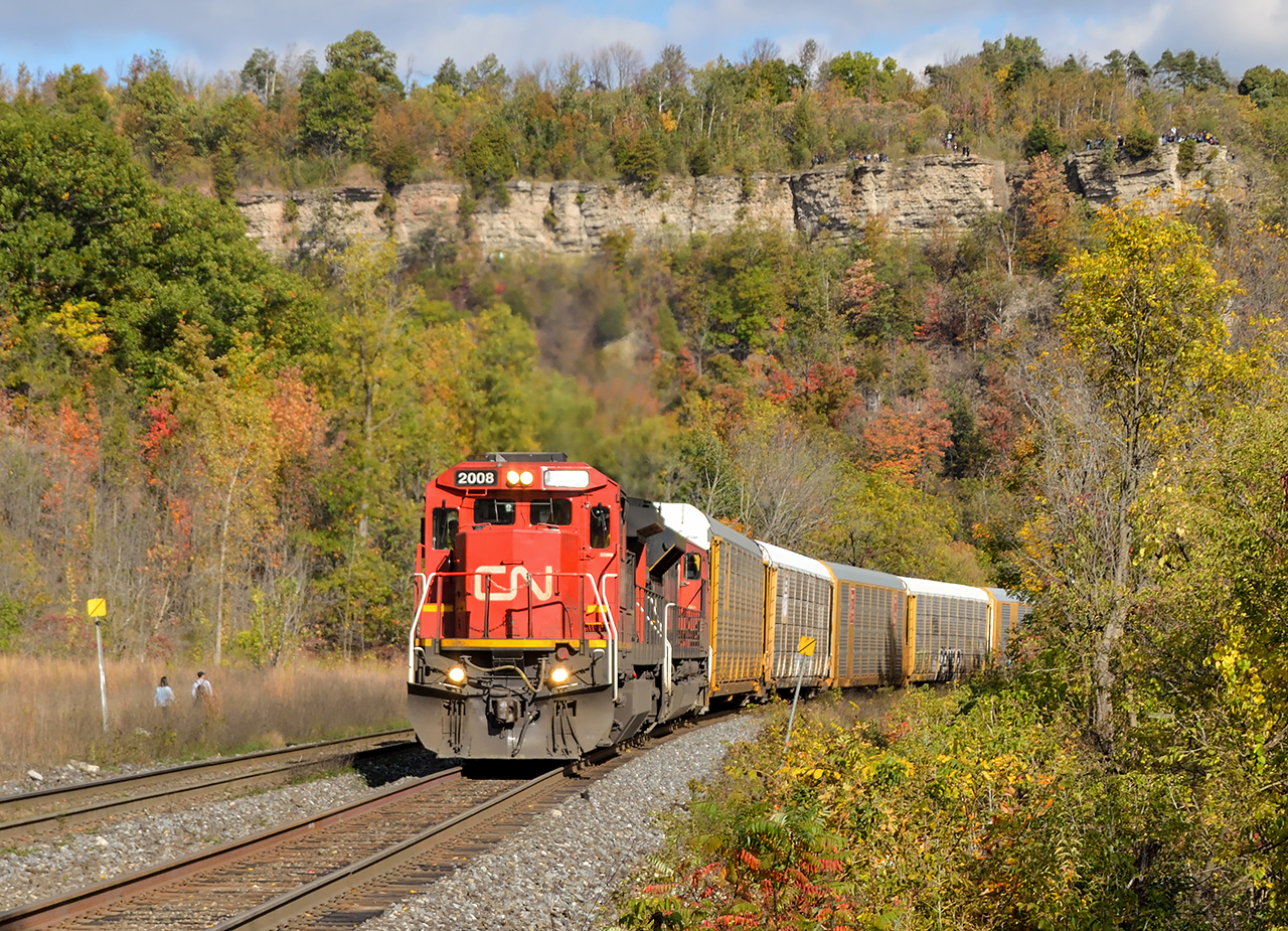 Hard to resist a standard cab dash-8 in great light.  After shooting M331 a short time earlier with 2452, the sun finally came out for E273's appearance working up the grade through Dundas.  With fall colours surrounding the area the peak is packed and more people seen at left are making their way up.
