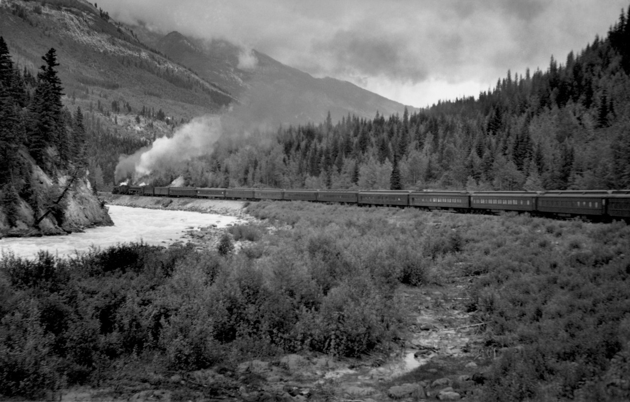 Train no. 4 with R class helper and T-1-b road engine in lower Kicking Horse canyon.  Exact locomotive numbers and location unknown.  Train had 15 cars.