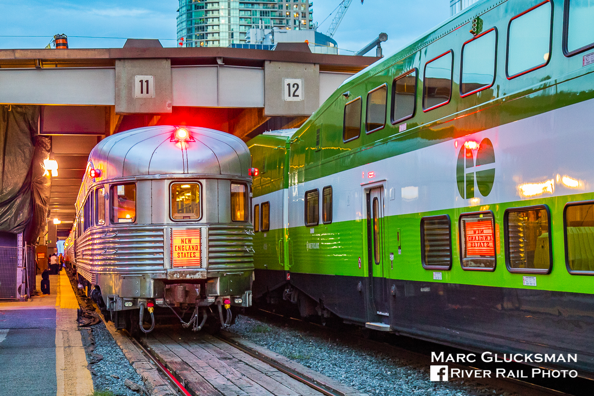 When you have the chance, GO. Amtrak 63/VIA Rail Canada 98 (Maple Leaf) has just arrived at Union Station in Toronto, Ontario on the evening of Tuesday, August 28, 2018 with former New York Central Railroad Budd built Pullman obs/diner/sleeper "Babbling Brook" (WEBX 800007) holding the markers. Although the car would make a quick turn, presently Amtrak service to Canada is listed as "cancelled until further notice" due to COVID-19 related travel restrictions, and it is a reminder to not to take any rail travel for granted. A GO Transit car frames the scene and provides a reflection of the "New England States" tail sign.