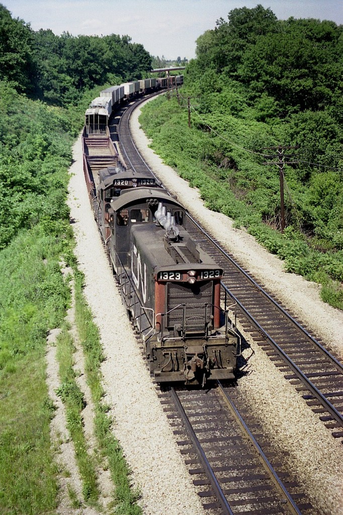 By the look of all the green, it must have been a rather wet spring in 1977. Such lush scenery.  I am on the Plains Rd West bridge shooting a CN local led by CN 1323 and 1320. Probably an Aldershot to Hamilton turn, but not really sure. By the end of 1994 both these units had left CN.