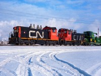 The 1343 and 1347 are making a long reach into the Sherritt Gordon fertilizer plant, located directly east of the City. The 1347 is one of the very few 1300's I have seen where the bottom cab windows have been filled in and painted. It also has the unusual cylindrical stacks on the arrestor, rather than the inverted cones, as on the 1343. The green of the John Deere combine is almost exactly the same as the BN flat car it rides on. The flat will be heading to the team tracks downtown by the elevators perhaps. Photo taken at 11:30 on a crisp January day.