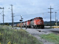 CN train 215 with very typical power, for the time period, crosses Young Street as it arrives in Capreol, Ontario on August 9, 1986.  Units are 9613-9576-9597.  The train had 69 loads 39 empties and 6994 tons.  With an HPT of 1.28, it will have no problem making track speed as it heads west. 