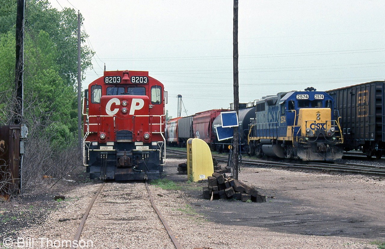 CP GP9u 8203 and C&O GP38-2 2574 are seen parked at the service area in CP's Chatham Yard on May 16th 2001. Note the blue flags hung on the nearby utility pole (affixed to a track rail in order to provide "blue flag protection" when a unit is being worked on).