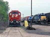 CP GP9u 8203 and C&O GP38-2 2574 are seen parked at the service area in CP's Chatham Yard on May 16th 2001. Note the blue flags hung on the nearby utility pole (affixed to a track rail in order to provide "blue flag protection" when a unit is being worked on). Also noteworthy is the orange and white "Sclair" covered hopper in the background.