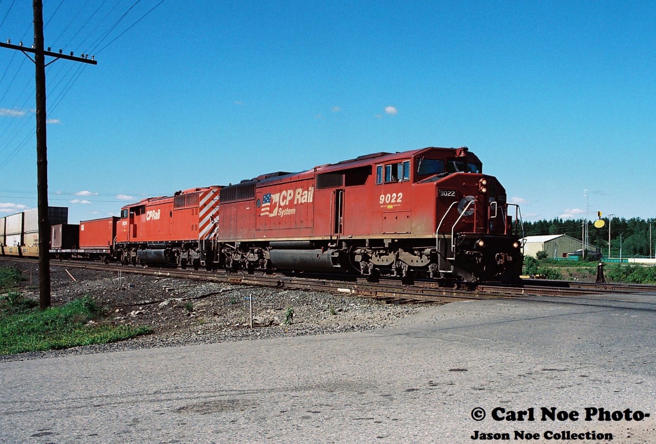 20 kilometers north of Sudbury situated along Highway 144 sits the small community of Cartier, Ontario. Here CP 418 with 9022 and 9024 is seen departing at the Spencer Avenue crossing after receiving a fresh crew as it heads toward Sudbury.
