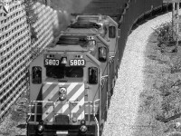 CP westbound 5803 with the 6024 and 5522 trailing, are approaching the east portal of a short tunnel at Katz on CPs Cascade Sub. The portal extends out from the cliff face, providing a concrete platform, perfectly sized to fit two photographers and their gear. Needless to say, we were covered in coal dust as the train passed through the tunnel. Fond memories in the making. 