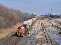 CN 2141 clatters across the turnout as it approaches Oshawa from the east. The train is E271, which predominantly handles automobile traffic but as seen here can also pull containers from time to time. Over the last few months CN has been putting an unusually high number of these endangered Dash 8 locomotives in the lead of trains on the Kingston Subdivision, and I'll continue to take full advantage of that while I can.
<br>
The pair of tracks on the right were once part of a yard that occupied all the open space between the mainline and the track furthest right. It's largely disappeared over the last few years with the closure of the Oshawa GM plant, but it was usually empty for nearly a decade prior to that. Now that it's been announced that Oshawa GM will be reopening, it's hard to say whether this yard and the others scattered around the plant will be used again. I hope that's the case, or at the very least I hope I get to photograph some new automotive trains here in the future.