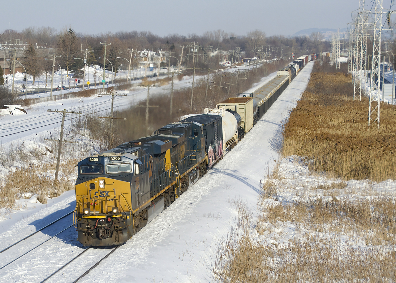 CN 327 has CSXT 3205, CSXT 477 and 84 cars as it heads west through Pointe-Claire.