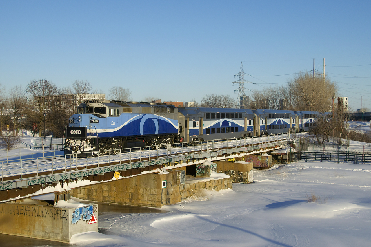 AMT 1340 is leading EXO 1207 for Mascouche over the Lachine Canal on the frigid afternoon after a snowstorm hit Montreal. I'm standing on a snowbank that is about 7-8 feet high for some elevation.