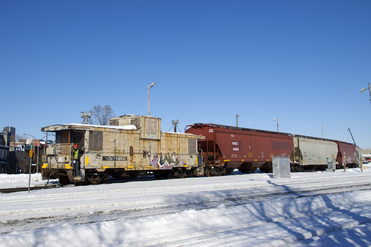 Once a common sight, a wave from a caboose is not something you'll see often these days. With the Pointe St-Charles switcher in Montreal now assigned a caboose for long backup moves, it can happen again when you get lucky. Here a crewmember waves as the train heads towards the Port of Montreal after shoving out of the yard as they pass MP 1.76 of the Montreal SUb. This van is not in great shape, but it is back home, as it was built by CN in their Pointe St-Charles shop in Montreal (now demolished).
