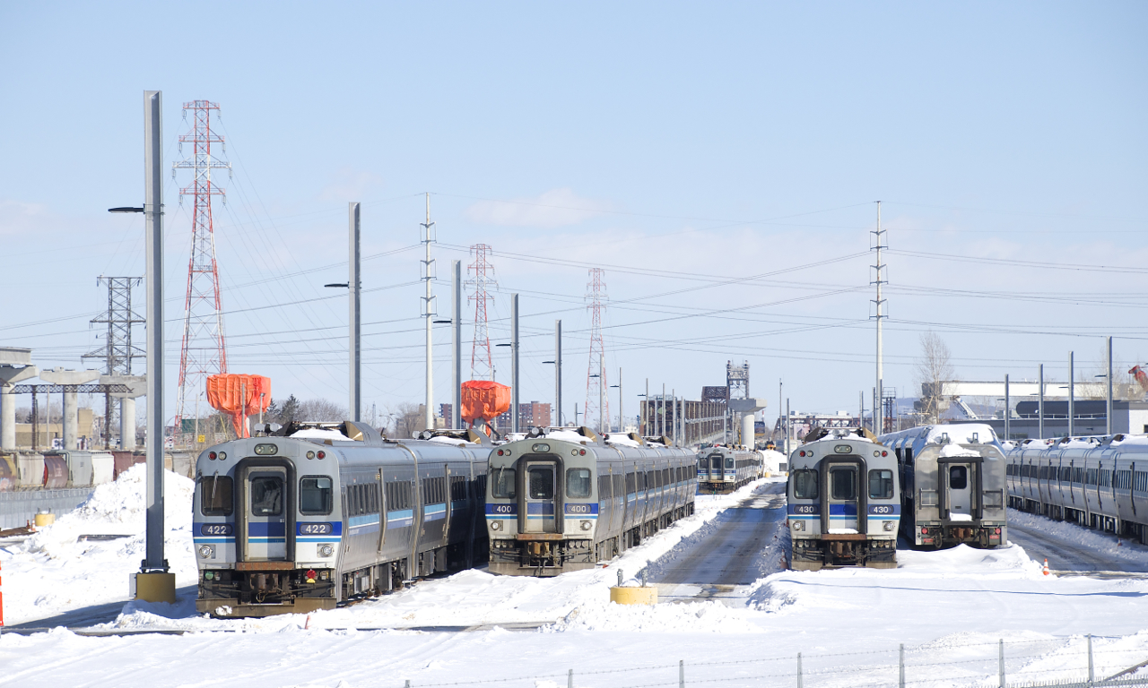 Numerous lines of MR-90 cars (surely the entire fleet) are stored at the Pointe-Saint-Charles Maintenance Centre, their service no longer needed and their continued existence very much in doubt. At far left can be seen the reason for their retirement, with REM construction ongoing here, as well as on the Deux-Montagnes line, where these cars were used until the entire line shut down at the end of 2020. Most of these cars had to be trucked from Deux-Montagnes to Saint-Jérôme, where they were put back on rails and brought here by F59PHI-led trains. The controversial REM project is a light rail line that will serve the Montreal area with grade-separated, driverless trains.
