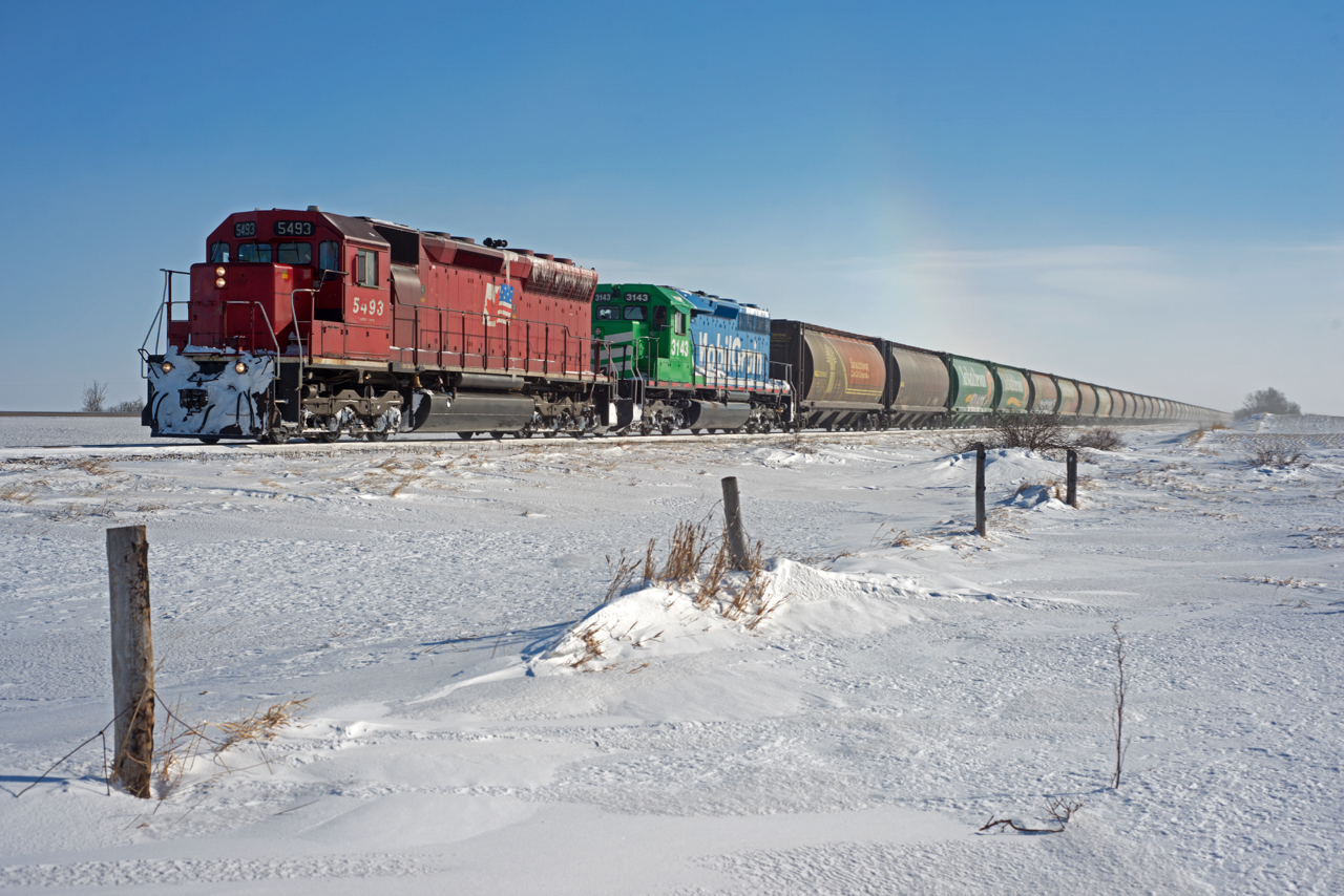 Modbil Grain's Last Mountain Railway has left home rails and is exercising trackage rights on the CN portion of of the Craik Subdivision near Bladworth Saskatchewan. Temperatures in the area were around -40C and if you look closely above the third car you can see a "sun dog" (basically a rainbow caused by ice crystals in the air).