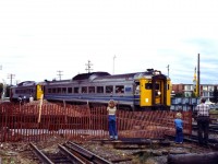 The last run of the VIA Havelock to Toronto train in 1982. At this time the replacement of the bridge over Jacksons Creek was underway with the main track severed and the old bridge removed. The lead RDC car has stopped on the diversion track adjacent to the new bridge structures on the right On the left it looks like a crew from CHEX TV is doing an interview of this event. Photo taken by my Mother.