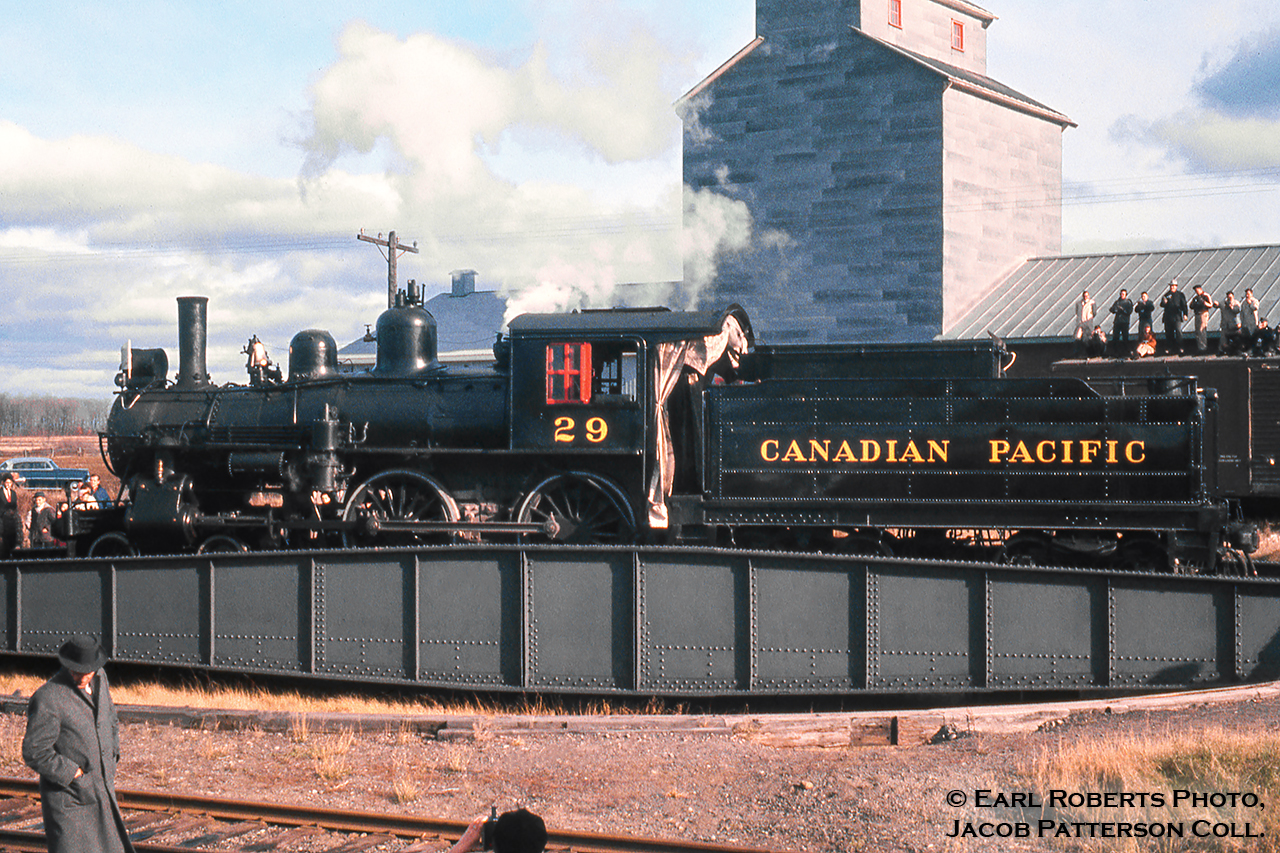 Canadian Pacific 29, one of the three famed 4-4-0s from New Brunswick takes a spin on the table at Saint-Lin-Laurentides, Quebec for its return trip to Montreal where its fire will be dropped for the last time.  November 6, 1960 marked the final day of CPR steam operation (until 2816 in 2001), and the occasion was marked with #29 leading an excursion from Montreal to Saint-Lin, a 74-mile total round trip via the Park Avenue, Ste. Agathe, and St. Lin Subdivisions.  A small ceremony was held near St. Lin Junction as the following day would mark the 75th anniversary of the driving of the last spike at Craigellachie, British Columbia.Built at CPR’s Delorimier Shops (Montreal) in 1883 as A-1-e CPR 390, the locomotive would be renumbered 217 in 1908, and finally 29 in 1913.  After retirement in 1960, the locomotive would be donated to the CRHA, later being sent to the Salem & Hillsborough Railway in New Brunswick where in 1994 it would suffer major damage in a roundhouse fire caused by arson.  Fortunately, Canadian Pacific recognized the heritage of this locomotive, acquiring it for cosmetic restoration in 1996 and placing it on display at their company headquarters in Calgary.  With headquarters moving from downtown out to Ogden in 2012, the locomotive remained downtown until June 2017, when it too made the trek to Ogden for cosmetic restoration.The 15.1-mile St. Lin Sub was built in 1877 with the first train operating on November 6 of that year (83 years to the date of this photo).  Originally the line had been chartered on December 24, 1872 as the Montreal & Laurentian Colonization Railway, branching off of the Montreal Northern Colonization Railway (later CPR Ste. Agathe Sub) at St. Lin Junction, and was to be constructed after the main line to St. Jerome was completed (October, 1876).  The line was renamed the Laurentian Railway Company on January 28, 1874 and would later be purchased by the eastward expanding CPR on March 13, 1882.  Passenger service ended on March 29, 1956 with the last train being hauled by G-2-s Pacific 2580 and the line would be abandoned October 1, 1963, torn up before year’s end.  The grain elevator behind would survive until late 2016/early 2017, removing all traces of the area’s past uses.Earl Roberts Photo, Jacob Patterson Collection slide.