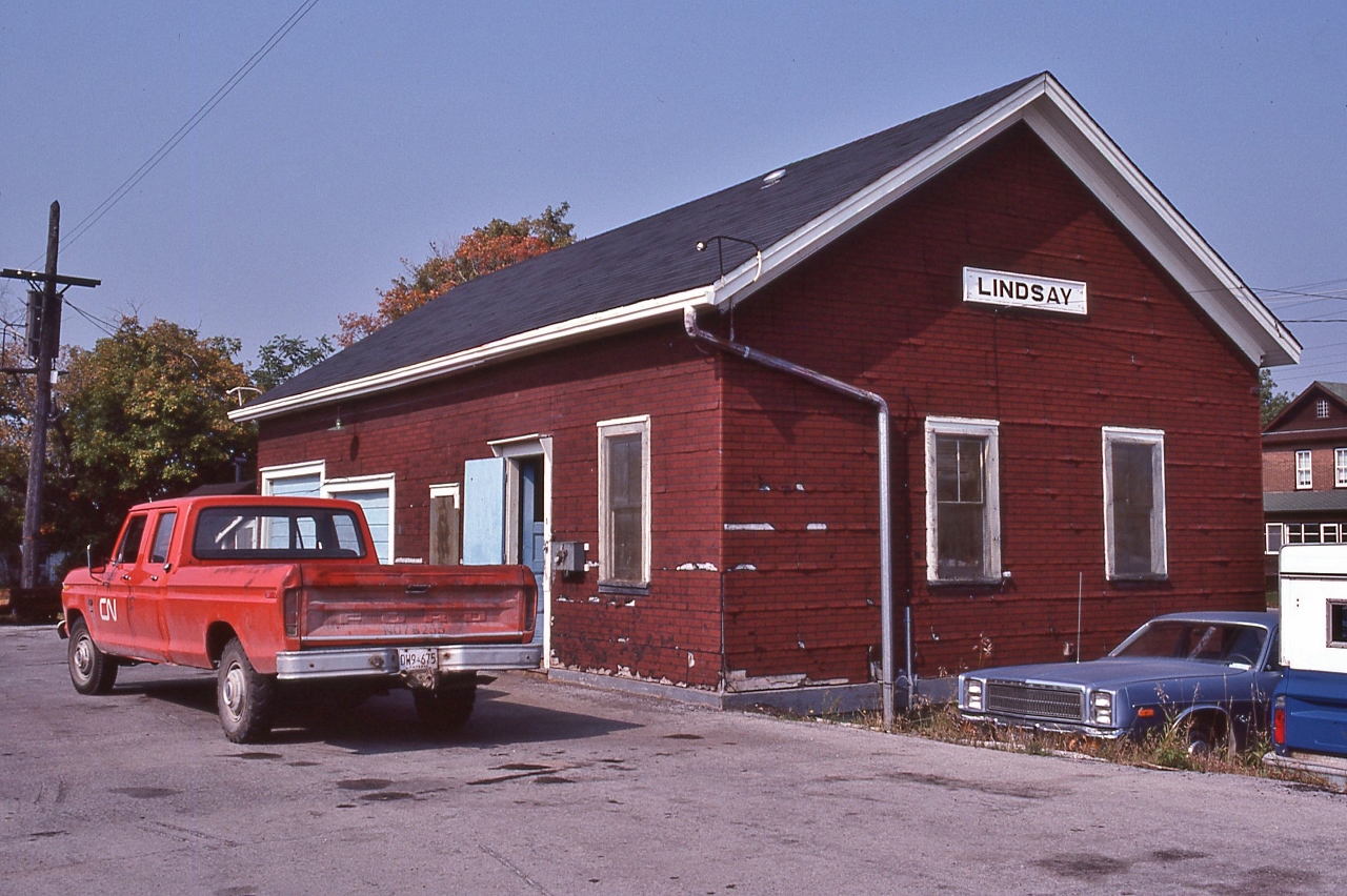 So, when is a railway building, a station ?


   Substituting for the removed passenger station, the express freight shed office handled station duties until the end of rail service.


   At the Lindsay Express Freight Shed Station, beside mile zero Uxbridge Sub., September 13, 1982 Kodachrome by S.Danko


   Noteworthy Lindsay musings: 


   The passenger station removed 1963, after passenger service ended in January 1962

  Ironically, the largest passenger trains to originate from Lindsay occurred after the passenger service ended and after the passenger station was removed ! 

   Two fourteen car passenger specials, June 24 and June 26, 1963, Lindsay to Morrisburg, Ontario conveyed students ( June 24) and general public (June 26) to the newly opened Upper Canada Village. ( references:  Keith Hasen, ' Last Train from Lindsay'.) [  the UCV school specials were common in mid sixties]


   Worth mentioning:


   Perhaps the second largest passenger trains - up to thirteen cars - to call in Lindsay were the several UCRS fan trips: 1963 powered by 6167 (retired 1964) and 1966, 1968 and 1970 (?) powered by 6218. At least two of those trips transited the 55 mile Haliburton Sub (track lifted 1983), powered by SW's north of Lindsay, and other trips transited over the entire Uxbridge and Campbellford Subdivisions.


   And perhaps the second last passenger train to visit Lindsay ( and transit the entire Uxbridge & Campbellford Subdivisions )   is the  1977  CRHA  (one way Montreal – Toronto ) trip powered by 6060. 


   Per Keith's book the last passenger train to visit Lindsay, the passenger-less Northlander – on a publicity tour, enroute from Belleville's 'Railway Days' celebration – stopped at the express freight shed station May 27, 1978 ! 

   Interestingly the ( express freight shed) station agent position survived to November 1980, meanwhile CP only occasionally entered Lindsay with abandonment in 1987 – I do recall seeing a CP Rail SW in Lindsay in '85.

  After the 1989 closing of the  Union Carbide plant in Lindsay, CN got its way, the last train rolled out of town in 1991. All rails throughout Lindsay ( & surrounding countryside)  pulled in 1992.


   6060 on the Campbellford
