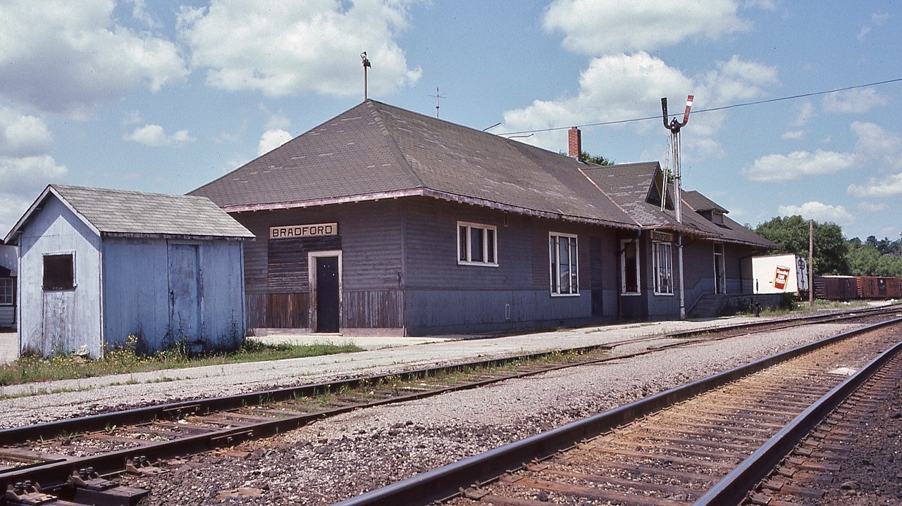 In the heart of the Holland Marsh, the GTR built Barrie Commuter train stop  - pre GO Transit
 

  at Mile 41.5 CN Newmarket Sub., Bradford, July 4, 1982 Kodachrome by S.Danko


 what's interesting:


  the Barrie Commuter train survived the  1981  VIA Rail service cuts * ( that eliminated 20% of VIA network) , the VIA replaced by the first GO train  ( Bradford as terminus) September  7 1982 (per wikipedia)   [ * the draconian 1990  VIA service cuts eliminated more than half of the VIA network  ] and the station is in GO service today.


 Perhaps the CN Bradford operator worked when deemed necessary? Traffic likely sufficient: the local freight and daily VIA & ONR trains # 1,  2, 121, 123 ( Fri Sun), 146, 147. The latter two the ex CN weekday Barrie commuters. 


  Most freight was routed on the Bala Subdivision, however I am aware that several times , the ONR pellet train operated southbound on the Newmarket – but whether this was on an exception basis is unknown


 at far right note the fruit / veggie temperature controlled box cars. 


  more Bradford

  

  VIA 9 with CP Rail