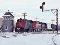 <br>
<br>
  CN extra 9647 west (white markers), with a dimensional, pulling onto the Dundas Sub (mile 76.8) at London Junction, from the Thorndale Sub 
<br>
<br>
   Powered by GMD built:  GP40-2L(W)   9647   /   GP40-2L(W)  9415  /   SD40  5xx2  (dynamic brakes)  
<br>
<br>
   at London, January 17,1981 Kodachrome by S. Danko
<br>
<br>
  Noteworthy: former Thorndale Sub now the west end of the Guelph Sub 
  
