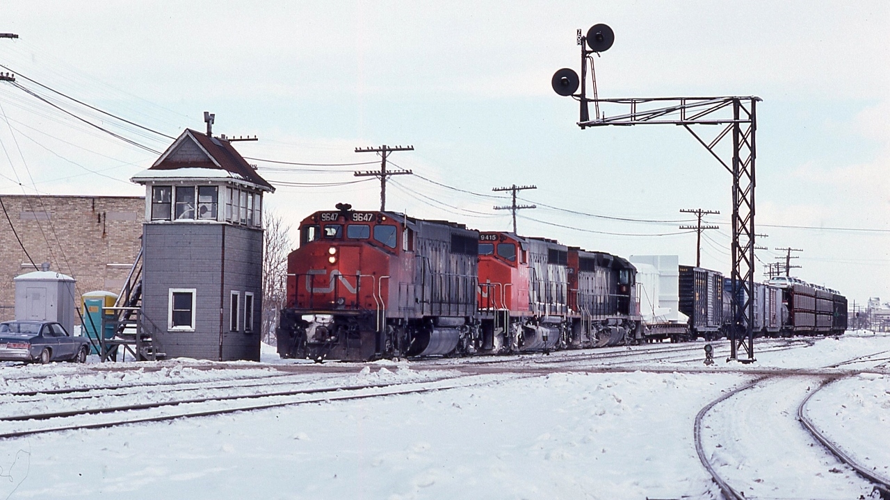 CN extra 9647 west (white markers), with a dimensional, pulling onto the Dundas Sub (mile 76.8) at London Junction, from the Thorndale Sub 


   Powered by GMD built:  GP40-2L(W)   9647   /   GP40-2L(W)  9415  /   SD40  5xx2  (dynamic brakes)  


   at London, January 17,1981 Kodachrome by S. Danko


  Noteworthy: former Thorndale Sub now the west end of the Guelph Sub