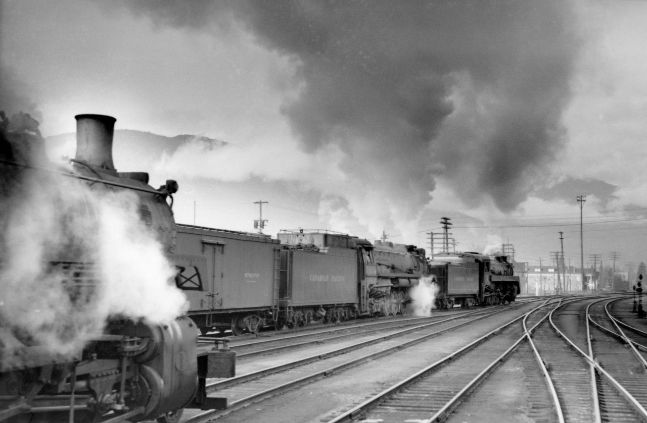 CP 5464 and 5912 doubleheader leaving Revelstoke with a westbound freight.  The engine on the left was an R-class.  They ran helpers west of Revelstoke a short distance to Three Valley or near there.  That was as far west as the selkirk engines were allowed to run.  They say the bridges west of there could not handle the weight of them.  When I was with the Engineering department at BC Rail, I ran the axle loadings of a selkirk through the Coopers bridge loading program.  I think it came out to Coopers E-65 on some of the shorter spans.