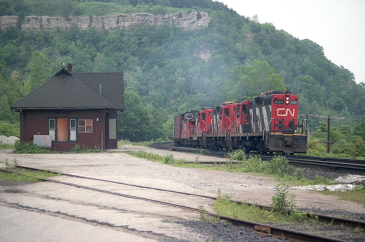 Normally I hide when it is hot and humid like so many July days are. I guess this must have been a cool and humid one. Anyway, up at Dundas, awaiting the #725 Hamilton to Nanticoke steel train; and was rather surprised to see it under control of three GP9s. On this day the power was CN 4125, 4121 and 4537. In a few short weeks the first two units would be renumbered into the 4300 series; but the last survived as is until around 1993. I thought the A-B-A series that powered this train must be finished, but they did return, as I saw various steel trains with As or Bs off and on up until late 1986.