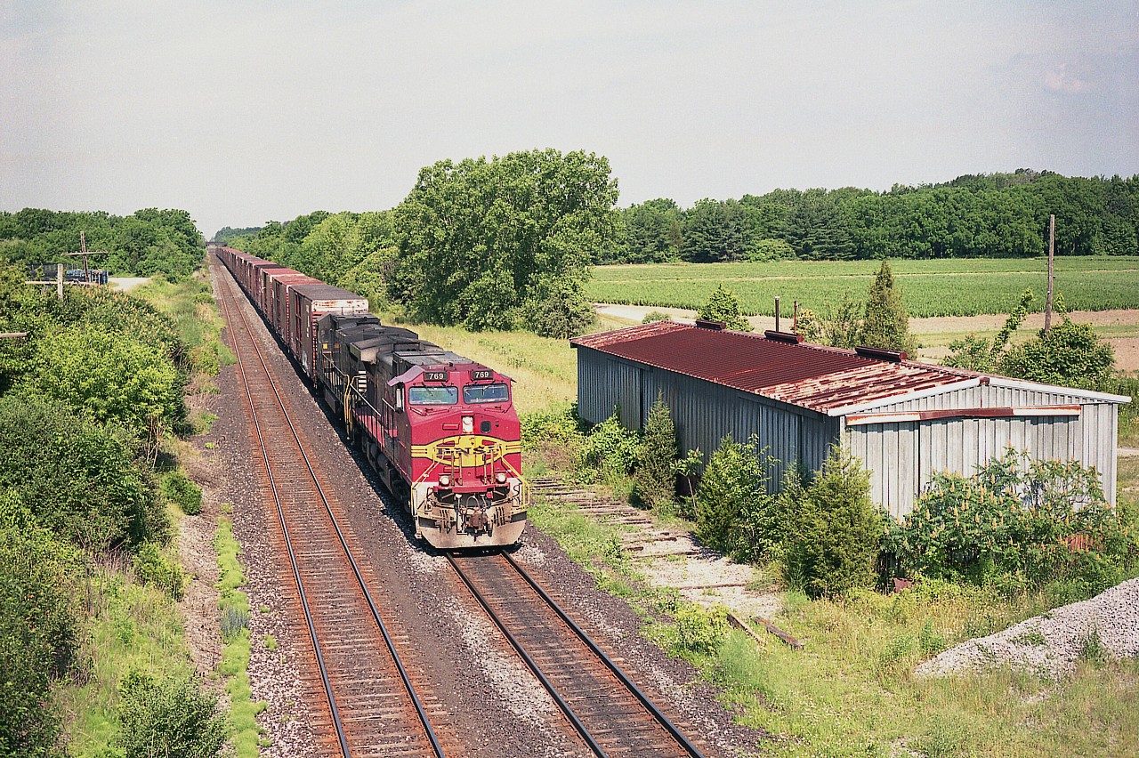 Just a few miles out of St. Catharines; NS autoparts train #328 rolls eastward. The Niagara area thru most of the early 1900s was THE fruit growing capital of Canada. Local trains stopped at every community, in season baskets of soft fruit were loaded in boxcars. By hand. Until the later days of pallets and, eventually; the railside activity ceased..
What is left in the peninsula is now shipped by truck. All the storage buildings along the way have been dismantled and sidings pulled out. In this view, you see the very last of those structures, and now this one is gone as well.
Interesting the sharp bright paint on this lead locomotive, a Warbonnet paint that must have been one of the last to get painted in that scheme. BNSF 769 and NS 8741 were photographed from the 9th St Louth overpass on a rather nice morning.