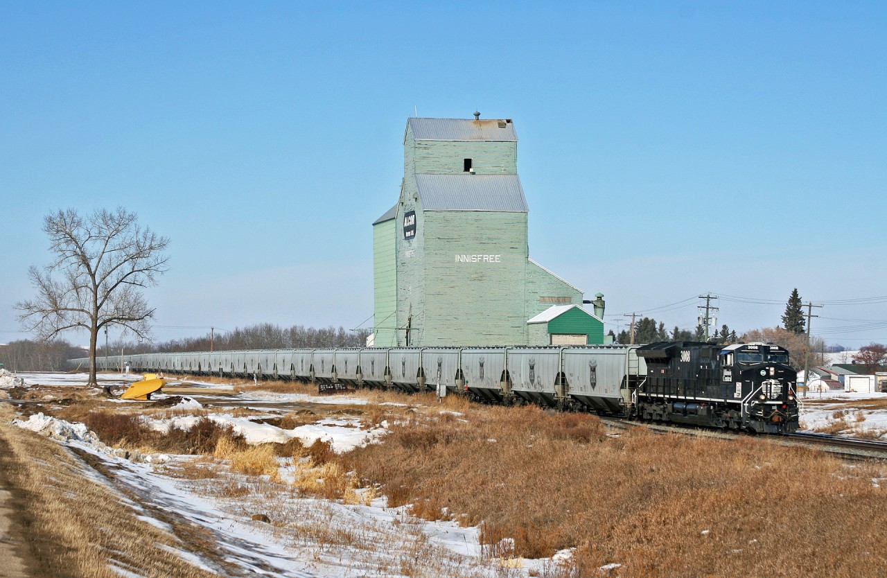 CN 3008 east slowly pulls past the old grain elevator at Innisfree, Alberta.