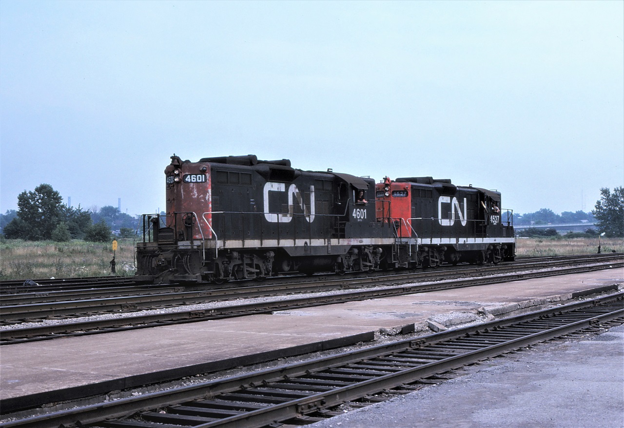 A pair of CN GP9s, lead by CN's highest numbered unit 4601 (pre NAR units) drift past the Niagara Falls station on July 16th, 1977.  The riders in the second unit, 4527, have the AC locked on the "high" setting!