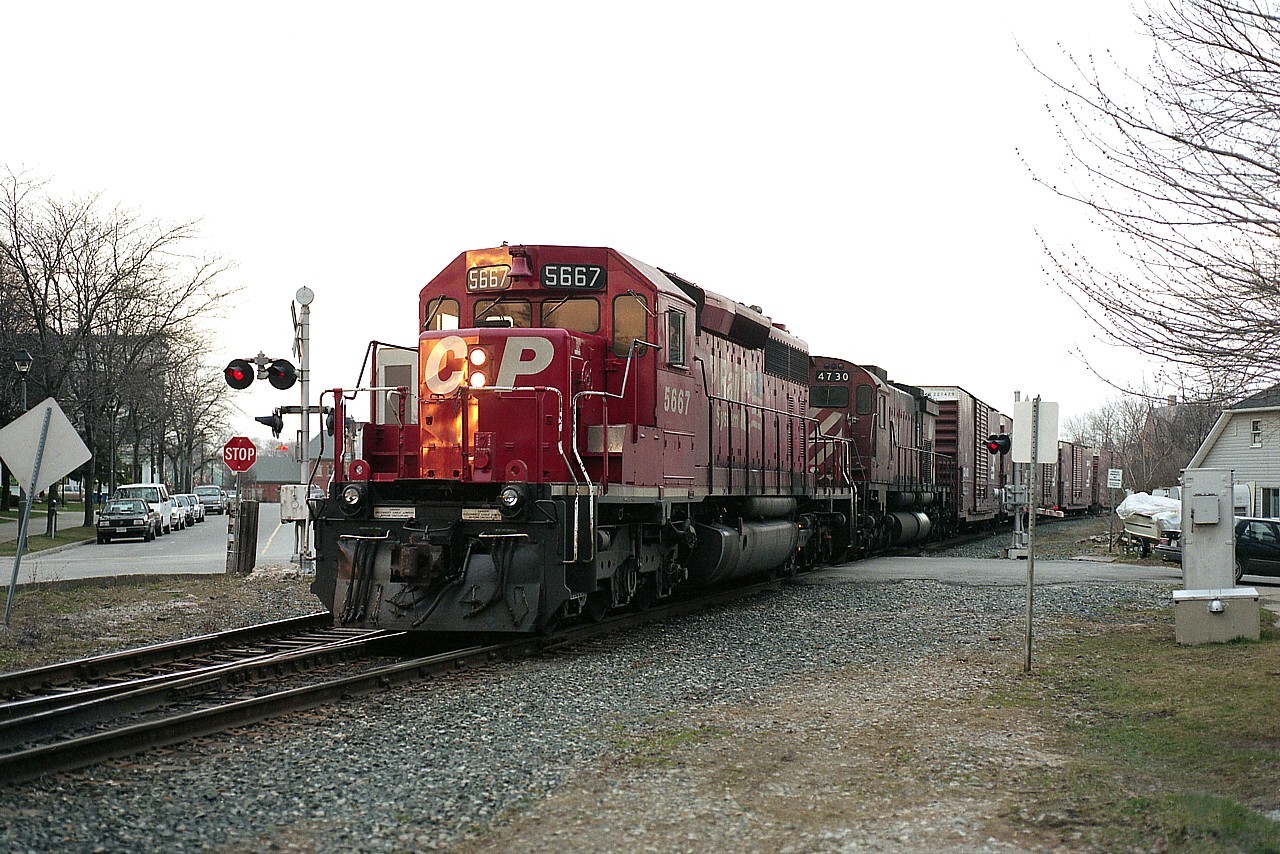 As usual, waiting for CP to come over from the USA means it is almost the end of daylight. The sun was so far down the horizon I elected to shoot from the opposite side of the tracks. The only light left is on the nose of the lead unit. (This location I noted for the last rays of sun while the rest of the line thru town was in shadow)  Here we see CP 5667 and 4730 just coming into Canada, photo from Huron St crossing. What I like about this image is that if you look right down Ere Av on the left, you can see the CN/VIA Station on Bridge St.