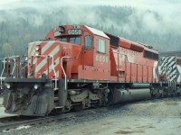 Revelstoke had some really great weather in the summer! However this photograph was taken in the fall when it liked to rain a lot! If I wanted to take photographs in the yard I signed my life away first, & then proceeded to wander around. Normally CP employees will notice a stranger quite quickly & question them. I wore a white hard hat that said "Canada" on the front of it so I got noticed real quick. Are you from "Transport Canada" they would ask and I would smile and say no. That answer got the employees to relax and forget I was there. For safety reasons hard hats are necessary, but they are also great for keeping your head dry.
All ways something good to see in Revelstoke in the 1980's but I guess you have to go to the newer CP yard in Golden BC now.