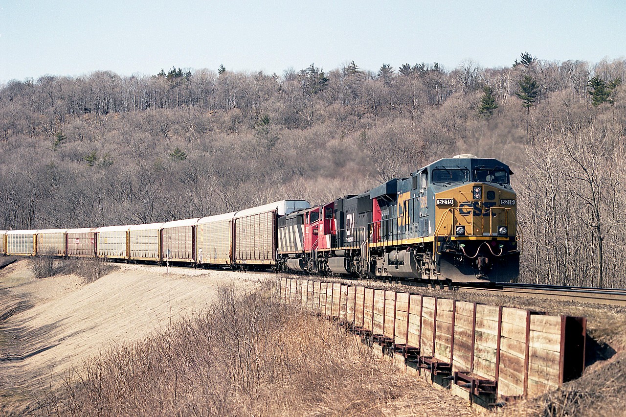 Awh....nice spring-like days......right around the corner as I type this. In this image, it is the 16th of March, 2006; early in the year, but plenty nice enough to be out.
At Dundas mile 2, I am standing at a spot just off to the west of York Rd bridge. This was a great location for shooting downbound (read: Eastward) trains for awhile,  2005 thru 2009, as CN had done a lot of work in shoring up the track bed, as you can see.  It only took a few years for foliage to take over, and now, despite a manicuring effort I attempted for a bit, is overgrown with thorn bushes and other ugly things you would not want to attempt to hack down.
Good while it lasted. Now, pretty much off limits. CSX 5219, CN 5647 and 5522 power this morning train, shot around 10AM. By noon the sun angle was poor.  Not often did I catch a CSX leader.