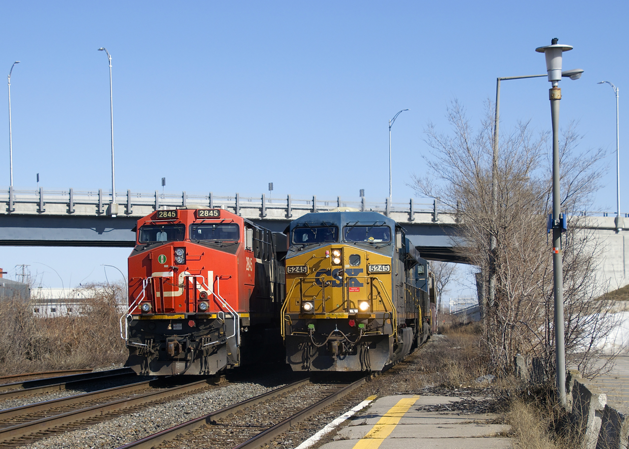 CN 327 with the usual CSXT power is passing empty grain train CN 875, which has been at Dorval since the previous evening. Just after CN 327 passes a new crew will get onboard and get ready to take it west.