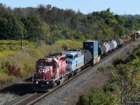 There's a story behind every photograph, and the one behind this photo of mine never ceases to get a laugh out of me. I was at Newtonville Road with my buddy <a href="http://www.railpictures.ca/author/canadian_railway_photography">Cam</a>, not expecting to see much but we stuck around for most of the day just in case. Cam looks at his phone, and reads a message from his friend in Cobourg saying there's an SD40-2 leader heading our way. The thing about this spot is getting from one bridge to the other, CN to CP and vice versa, requires a fair bit of walking (or running). We were camped out at the CN bridge, and against our better judgement we chose to wait there thinking this train was further away. <b>Spoiler alert: it wasn't.</b> Within five minutes Cam turns away and goes silent, then yells "Hey, I think I see it!". Of course, if Cam can see the train from here, it's already pretty close. We're both running at full speed to get to the other bridge in time. Not even halfway there and we hear it blow the horn for the Lancaster Road grade crossing, and only now do we realize how close it is and that we might not make it in time. Somehow, we managed to get there just before it crossed the tree line and we were able to snap a few photos before it passed us. This train came with Central Maine & Quebec 9011, an SD40-2F of CP heritage, trailing second. Throughout 2020, these engines made appearances all over Ontario. As the former CMQ track was being upgraded to CP standards, ballast trains were regularly going back and forth between there and Sudbury. This is one of those trains, swelled with several other freight cars and MOW equipment it picked up in Smiths Falls. Having missed out on seeing these locomotives pull mainline trains ten or more years ago, it was nice getting this chance to capture them in action.