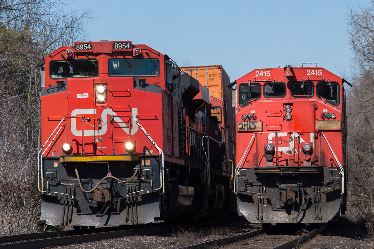 CN 148 with CN 8954 cruises by CN A402 with the CN 2415 leading at Hardy Road in Brantford.  402 had to hold at Hardy to wait on CN L580 to clear the Hagersville Subdivision before they could head down to Garnet.  Shot a 200mm from the public crossing.  Also on my lunch break!