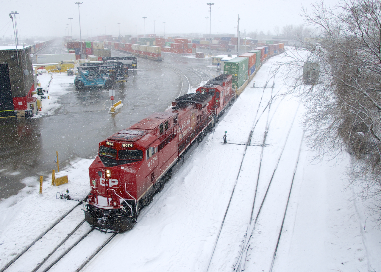 CP 112 is pushing a final cut of cars into Lachine IMS Yard on a snowy morning. Soon it will grab its mid-train DPU, then non-intermodal cars and its rear DPU before heading to St-Luc Yard.
