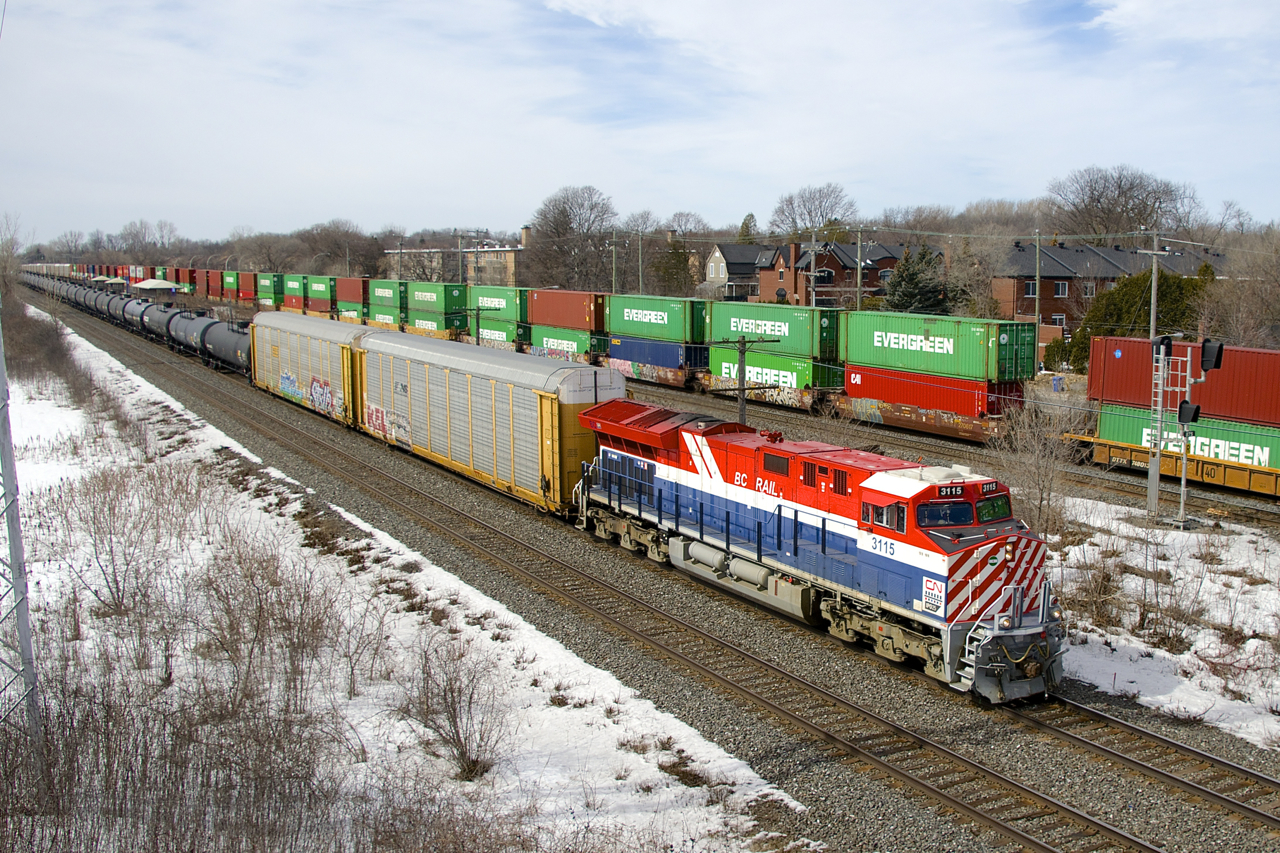 Heritage unit CN 3115 leads CN X306 east, with CP 112 at right heading in the same direction on the parallel Vaudreuil Sub.
