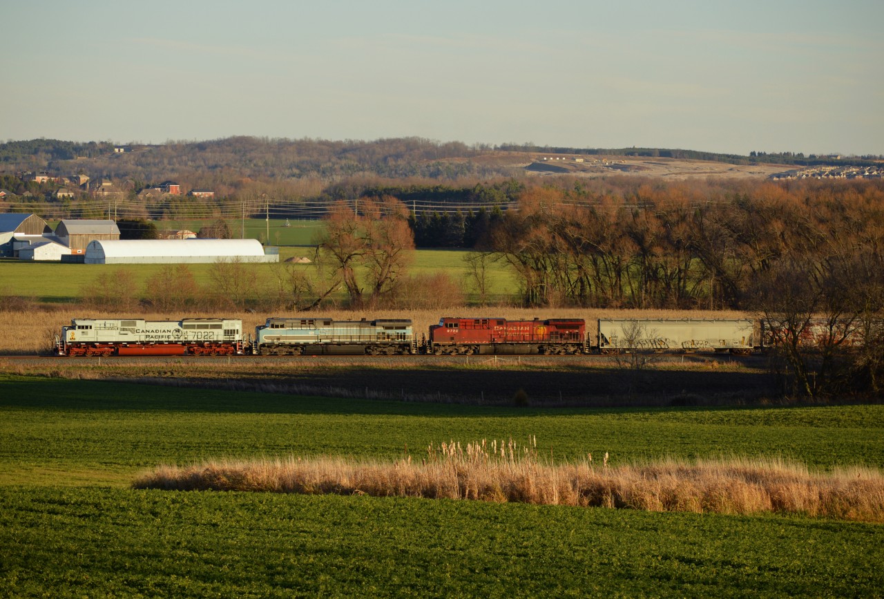 CP 113 approaches a waiting 420 in the siding at Baxter with a colorful consist of CP 7022 (Navy "Shipside Grey" scheme), CEFX 1002 (sporting CMQ paint), and CP 9729 (wearing nothing special) on the head end.