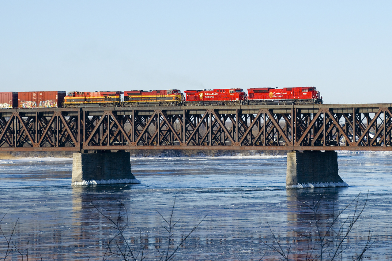 CP 253 is crossing the St. Lawrence River with two CP and two KCS units, split between EMD's and GE's (CP 7033, CP 9633, KCS 4143 & KCSM 4677). At the end of the train are the empty tank cars of CP 651.
