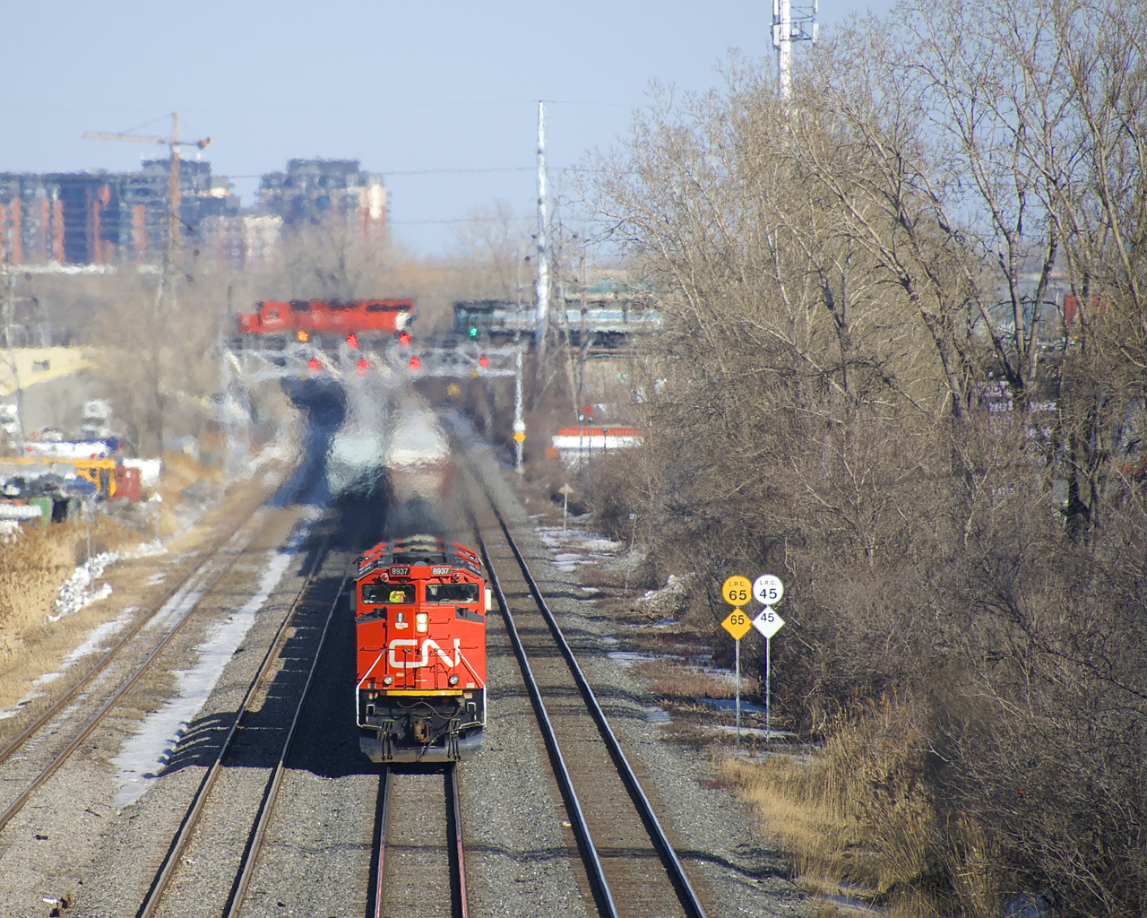 CN 527 with a trio of SD70M-2's is approaching Taschereau Yard as CP 251 appears in the distance with CP 6018 & CEFX 1002, crossing over CN's Montreal Sub on CP's Adirondack Sub.