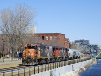 The Pointe St-Charles Switcher has a GP38-2, A GP38-2W and two GP40-2L(W)'s (CN 4729, CN 4774, CN 9576 & CN 9523) as it backs up towards Ardent Mills to pick up grain empties. It has come straight from the Port of Montreal and so has four cars picked up there. A crewmember enthusiastically waves from the lead unit.