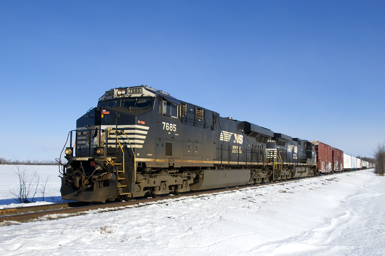 Almost never running in daylight these days, a very late CN 528 is on its way to Rouses Point with NS 7685, NS 9441 and 40 cars on a brutally cold and windy morning. There it will get a CP crew and continue south as CP 930.