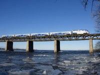 EXO 78 from Candiac is approaching the island of Montreal during the morning rush hour. Large chunks of ice are flowing down the St. Lawrence river on a cold morning after a warm day.