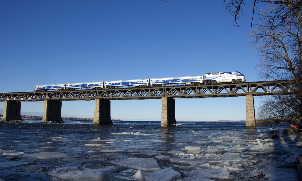 EXO 78 from Candiac is approaching the island of Montreal during the morning rush hour. Large chunks of ice are flowing down the St. Lawrence river on a cold morning after a warm day.