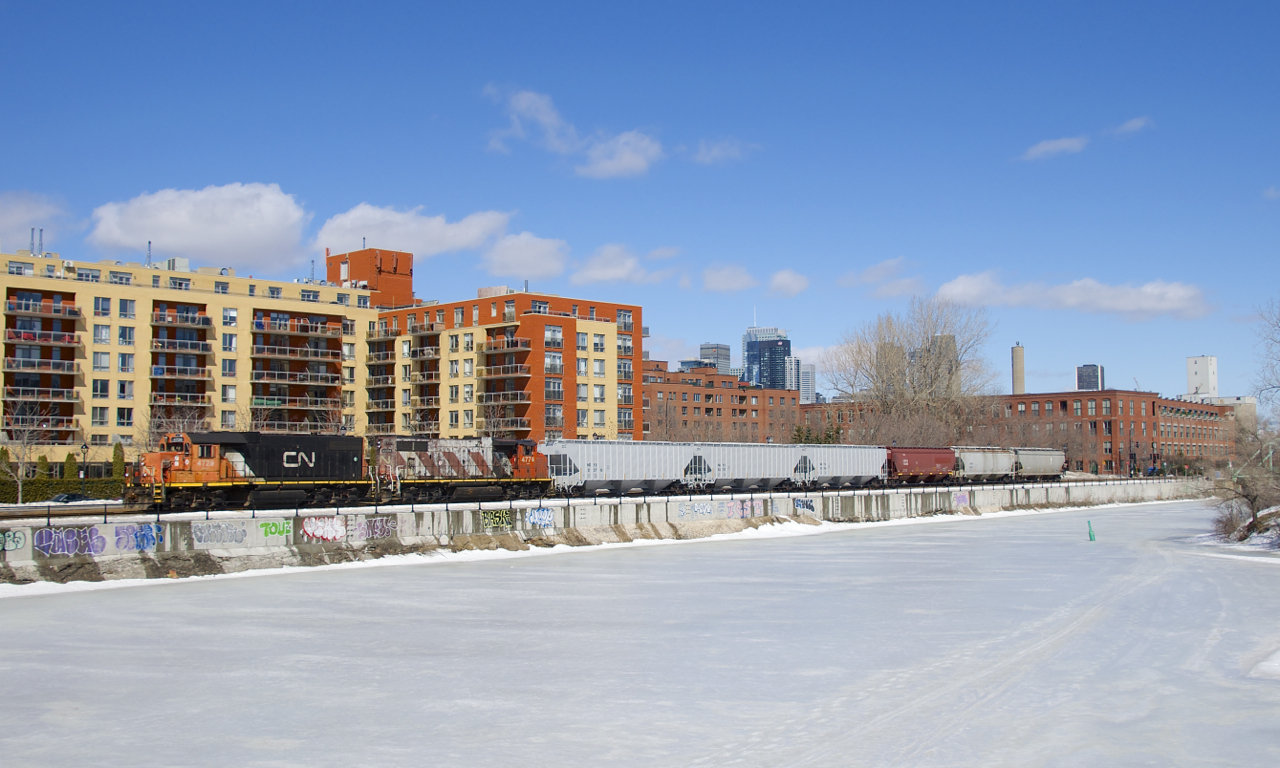 The Pointe St-Charles Switcher is shoving 6 grain cars towards the Ardent Mill, the last client remaining along the Lachine Canal. CN and CP once served dozens of clients along the canal, but the area has become increasingly gentrified.