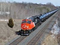 <br>
<br>
  Crude East:  Nearly new  CN 2817 with DPU 2923, two GE GEVO-12 ES44AC's built January 2013 and December 2014, 
   <br>
<br>
   are clear of the Newtonville cross overs, on approach to Wesleyville in the rolling Northumberland Hills
<br>
<br>
  At Stacy Road, March 18, 2015 digital by S.Danko
<br>
<br>
  Notable: Crude Oil by Rail volumes are ramping up significantly from the 2020 record low volumes, industry pundits are anticipating significantly more crude oil by rail volumes throughout 2021, and should Enbridge Line #5 – the main oil line through Michigan to Sarnia – goes down, oil ( and related products) and gasoline prices will change dramatically as will Crude Oil by Rail volumes.  



