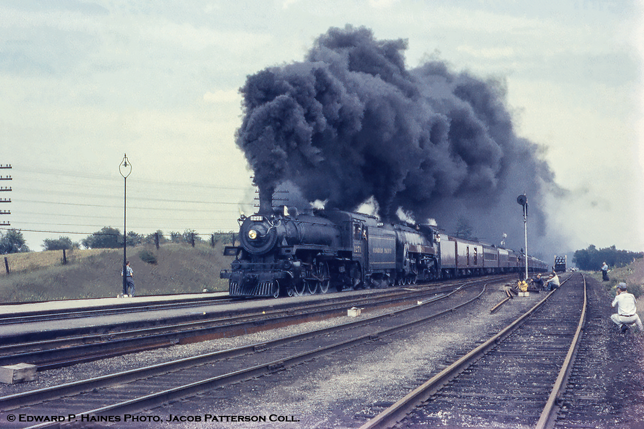 Railfans all over, trackside, on the platform, and of course - look closely - on the signal mast.  The annual NRHS Buffalo Convention was held in Toronto at the end of August in 1958 featuring a two day set of excursions, one over the CPR and one over the CNR the following day.  Here we see the CPR train led by Pacific 1271 and Royal Hudson 2838 charging uphill belching smoke for all the fans.  Having departed Toronto Union, the train would head south from Guelph Junction to Hamilton returning to Toronto over the CNR's Oakville Subdivision.By this time only four steam locomotives (including the two pictured) were still active out of John Street, 1271 (last G5c Pacific, built by CLC April 1947), Royal Hudson 2838 (H1c, MLW 1937), 1265 (G5c, CLC 1947), and 2399 (G3g, CLC 1942), all of which would be retired and scrapped in the near future.  Thanks to Ray Kennedy for information.Bill Thomson shot here looking west about a year later showing the steam era facilities located at the junction, the unique two track, four locomotive engine house hidden in behind.Edward P. Haines Photo, Jacob Patterson Collection Slide.