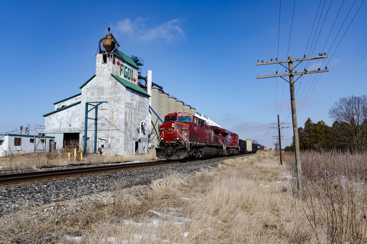 CP 235 passes the abandoned grain elevator near the village of Louisville. I believe CP had a passing siding here at one point, but it has since been removed along with the rail for the elevator. Most of the code line is still intact in this section of the Windsor Sub giving it that retro look still.