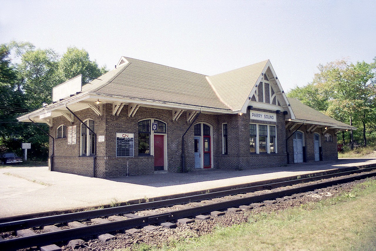 I'm sure most of the railfan wanderers are familiar with this station. It really has not changed all that much in the 45 years since I shot this photo. But it has not been used by CN in many years.
I recall it being a Chamber of Commerce with also MTO offices there. Hunting, fishing licenses also available. They moved out. In 2017 the town offered up the station for sale and it sold for just over $100,000 I understand. Not bad for 2900 sq ft in a solid building such as this. The station was designated architecturally and historically significant in 1983; so the exterior of the building is not to be altered no matter who takes it over. The buyer in 2017 was going to develop a banquet facility there, I heard; but nothing happened. In 2019 a business called "Rainbow Sound" (music and instruments) was going to be open by the fall of that year, but again, nothing happened. I guess a 'cheap' purchase isn't that cheap after all if there is no money coming in at said property. Last I saw of it, Oct 2020; it was empty and for lease.  Beautiful structure, and has held up very well since its' construction back in 1932.