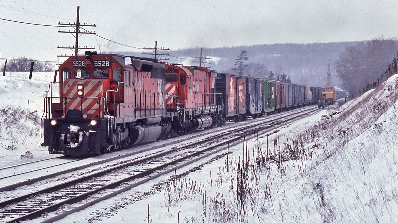 White Flags flapping, a ubiquitous SD40 assists M-636 #4735 on the grade up to Guelph Junction


  The local CP Rail Foreman occupies the south track with a Burro crane, flat and caboose


  Extra 5528 west, on the approach to Guelph Junction, January 18, 1981 Kodachrome by S.Danko


  more Campbellville action:


    push service