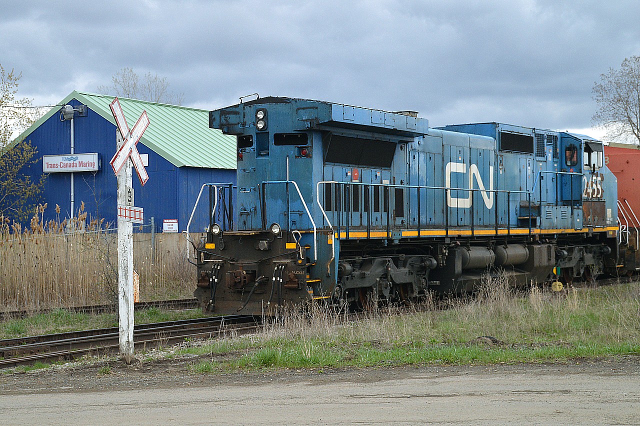 I decided to post this as a follow-up to Geoff Elliot's really nice country setting photo with #2456 in the lead, photo #45134. It was great to see an old X-LMSX on the lead; but this image presented shows not all in that series are so lucky to be out there on the line.
At the old Martech facility in Welland, a number of CN locomotives are to be stored for scrap, either on site or elsewhere I am not sure which. Here we see CN 2455, a "fallen blue" about to be pushed across Rusholme Rd by company Centre cab #615 into the the Martech fenced compound to await its' fate. This is the end of the line. Quite a few more units there will eventually meet the same demise.